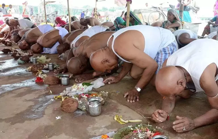 A group of people bowing down to dharti in respect during Pind Daan poojan