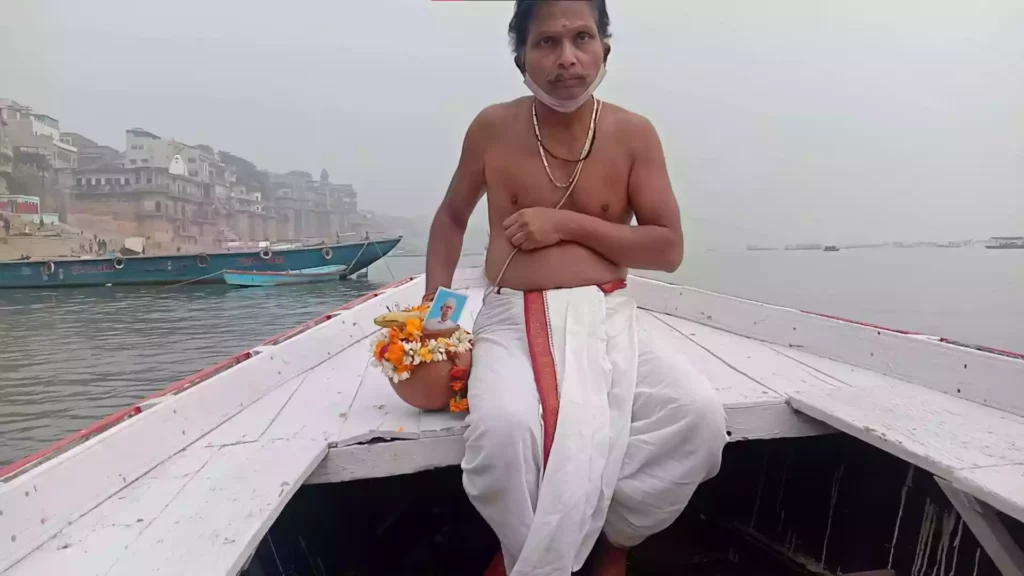 Image of a person performing asthi visarjan in varanasi