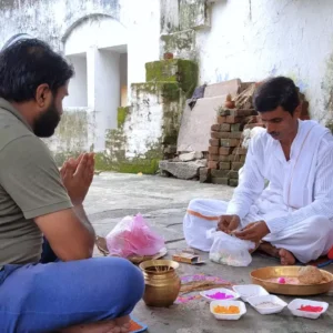 A devotee sitting with Pandit below Akshayavat tree in gaya performing shradh-Role of Akshayavat in Gaya Shradh Shradh at Prayagraj