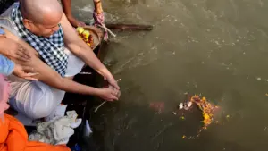 A family performs ancestral rites from a boat, releasing sacred flower offerings into the holy sangam- NRI shradh puja Prayagraj
