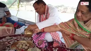 Image of A couple perform pind daan in boat in triveni sangam prayagraj- Prayagraj pilgrimage from Malaysia