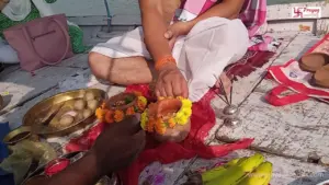 Image of A couple perform Asthi visarjan in boat in triveni sangam prayagraj- Prayagraj pilgrimage from Malaysia
